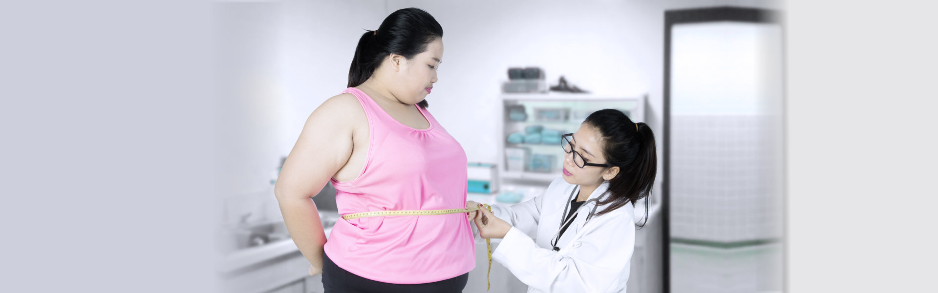 a doctor checking the waist measurement of the girl